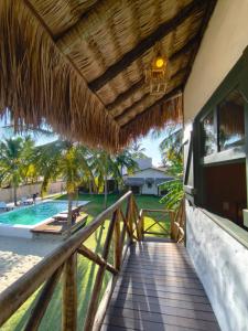 una pasarela de madera que conduce a un complejo con piscina en Villa Flora, en Amontada