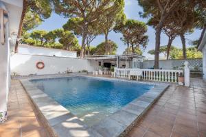 ein Swimmingpool in einem Hinterhof mit Bäumen im Hintergrund in der Unterkunft Chiclana Boutique Oasis del Mar in Chiclana de la Frontera