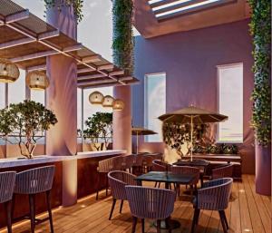 a restaurant with tables and chairs and windows at Trizen Colombo Luxury 3 Bedroom Apartment in Colombo