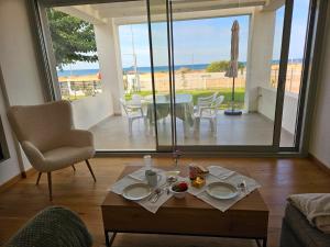 a living room with a table and a view of the ocean at Villa Jolanta in Sevastí