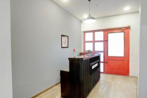 an empty room with a red door and a counter at Townhouse Nagpur Junction Formerly Hotel Woodland in Nagpur