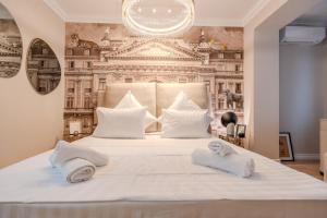 une chambre avec un grand lit blanc avec des serviettes dessus dans l'établissement Urban Jungle Suite - by BLVD, à Bucarest