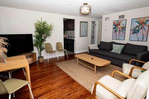 a living room with a couch and a tv at Slow Pace Beach Living - Pool - Steps from Beach in Jacksonville Beach