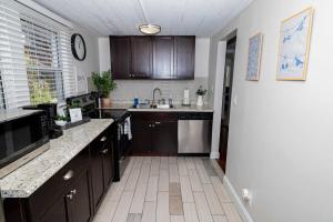 Una cocina con gabinetes de madera y encimera. en Slow Pace Beach Living - Pool - Steps from Beach, en Jacksonville Beach 30 fotos más