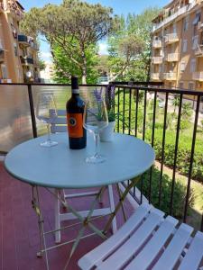 a table with two glasses and a bottle of wine on a balcony at Studio apartment in the center in Lido di Ostia
