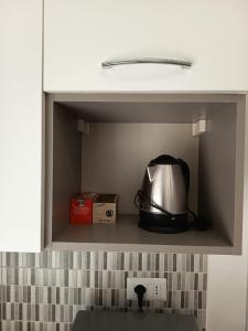 a tea kettle is sitting inside of a cabinet at Studio apartment in the center in Lido di Ostia