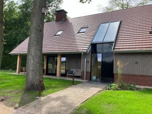 a house with a large window and a tree at Landgoed Erve Triesthaar in De Lutte