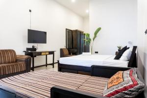 1 dormitorio con 2 camas, escritorio y TV en Juula lagoon resort Hikkaduwa, en Dodanduwa