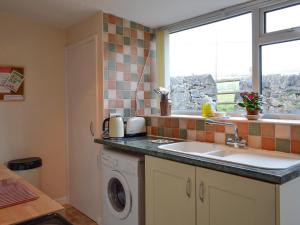 a kitchen with a sink and a washing machine at Forest View in Peak Forest