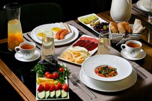 a table with plates of food and cups of tea at Escapes Boutique Hotel & Restaurant in Dilijan