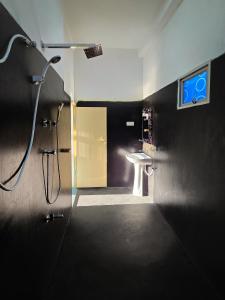 a bathroom with a shower and a sink and a door at Sammy Villa Tangalle in Tangalle