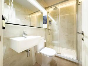 a bathroom with a sink and a toilet and a shower at Ópera Stays by Charming in Madrid
