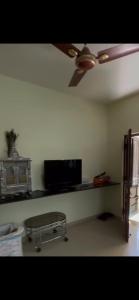 - un salon avec un ventilateur de plafond et une table dans l'établissement Ram Niwas Villa 3 Bedroom Home, à Vadodara