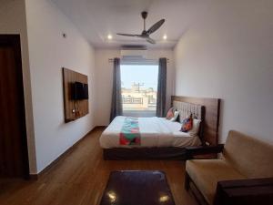 a bedroom with a bed and a couch and a window at Hotel Global Inn Glod in Lucknow