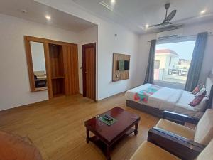 a bedroom with a bed and a couch and a table at Hotel Global Inn Gold in Lucknow