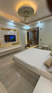 a bedroom with a large white bed in a room at HeavenStay Omaxe Hazratganj in Lucknow +4 photos