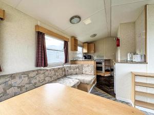 a living room with a couch and a kitchen at Cosy Caravan With Free Wifi At Sand Le Mere Holiday Park, Ref 71009R in Tunstall +8 photos