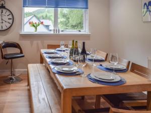einen Holztisch mit Weingläsern und Weinflaschen in der Unterkunft Tamarchan Lodge in Ballachulish