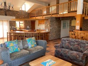 a living room with two couches and a kitchen at Net Net Holiday Home in Witsand
