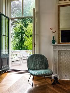 a green chair in a living room with a fireplace at Parc Broekhuizen l Culinair landgoed in Leersum