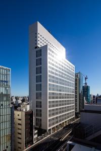 a tall white building in the middle of a city at Hotel Crown Hills Ueno Premier in Tokyo