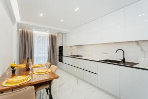 a kitchen with a wooden table and a sink at Apartment lux in Chişinău
