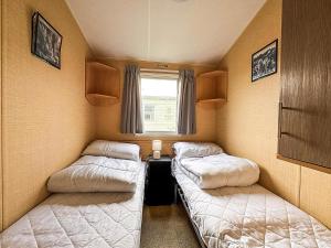 two beds in a small room with a window at Homely, Dog Friendly Caravan At Sand Le Mere In Yorkshire Ref 71005O in Tunstall +14 photos