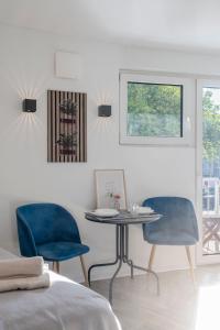 a room with a table and two blue chairs at SpaceStays Bunker Messe Apartment Wi-Fi TV in Essen +8 photos
