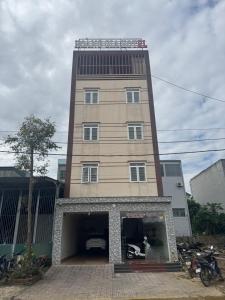 a tall building with a motorcycle in a garage at Hotel Hoàng Gia in Pan Linh