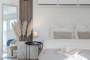 a white bedroom with a bed and a mirror at SpaceStays Bunker Messe Apartment Wi-Fi TV in Essen