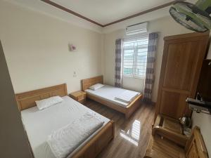 a bedroom with two beds and a window at Hotel Hoàng Gia in Pan Linh