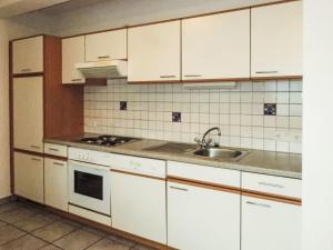 a kitchen with white cabinets and a sink at Apartment Kristall-1 by Interhome in Fendels