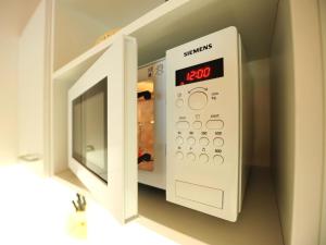 a microwave oven with its door open with the clock at Studio Alpelux-2 by Interhome in Jerzens +12 photos