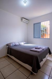 a bedroom with a large bed with a window at Casa da Alice in São Carlos