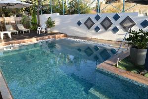 une piscine avec une table, des chaises et un parasol dans l'établissement Villa Corin, à Gornot HaGalil