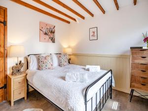 a bedroom with a bed and a dresser at The Old Cowsheds 1- Dairy - Uk49786 in Cribyn +8 photos
