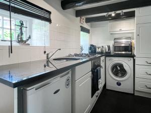 a kitchen with a sink and a washing machine at White Cottages in Whitby