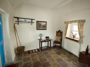 a room with a table and a chair and a window at Coelard Farmhouse - Usj in Appin +2 photos