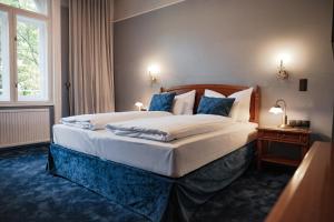 a bedroom with a large bed with blue pillows at hideauts hotels Villa R in Vienna