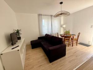 a living room with a couch and a table at Charmante maison calme proche gare TGV Saint-Pierre-des-Corps in Saint-Pierre-des-Corps