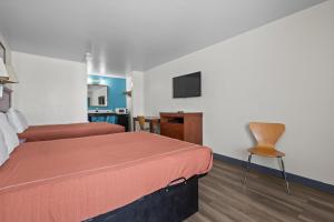 a hotel room with two beds and a television at Capital O First Heritage Inn Rantoul IL I 57 in Rantoul