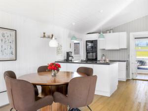 Holiday Home Quanna - 450m from the sea by Interhome في Hejlsminde: مطبخ وغرفة طعام مع طاولة وكراسي خشبية
