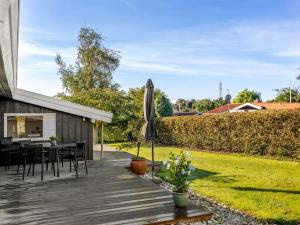 Holiday Home Quanna - 450m from the sea by Interhome في Hejlsminde: سطح خشبي مع طاولة ومظلة