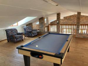 a pool table in a living room with two chairs at Net Net Holiday Home in Witsand