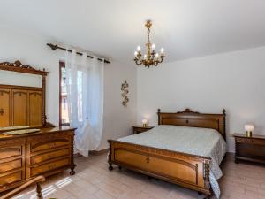 Holiday Home Papaveri e Papere by Interhome في Piano Porlezza: غرفة نوم بسرير وخزانة وثريا