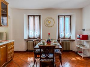 a dining room with a table and chairs and windows at Holiday Home Papaveri e Papere by Interhome in Piano Porlezza +24 photos