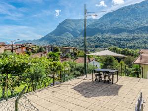 a patio with a table and a view of mountains at Holiday Home Papaveri e Papere by Interhome in Piano Porlezza