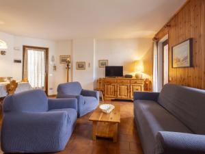 a living room with two blue couches and a table at Apartment Oga Mountain Home by Interhome in Oga
