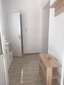 a white room with a wooden table and a door at HannaFlora in Mali Iđoš