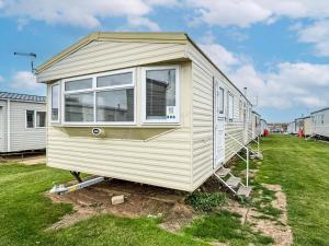 a tiny house is sitting in a yard at Lovely 8 Berth Caravan At Harts Holiday Park In Kent Ref 74066B in Sheerness